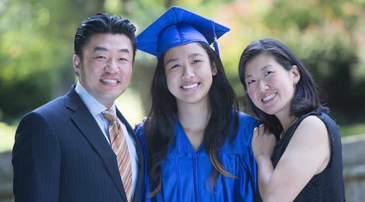 asian female graduate hugging parents
