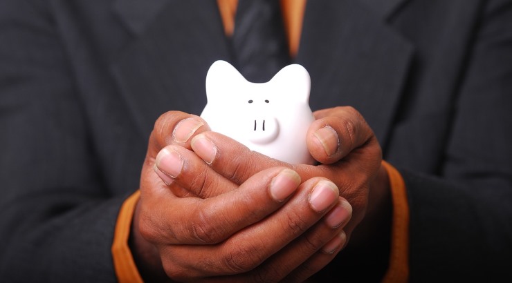 man in suit holding piggy bank