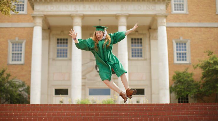 graduate jumping in cap and gown