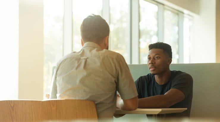 two men talking at table