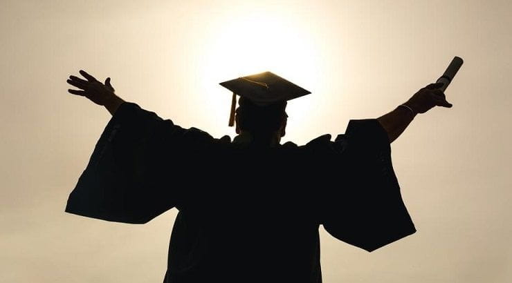 graduate with arms in the air