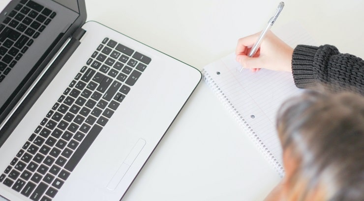 writing on notepad and laptop