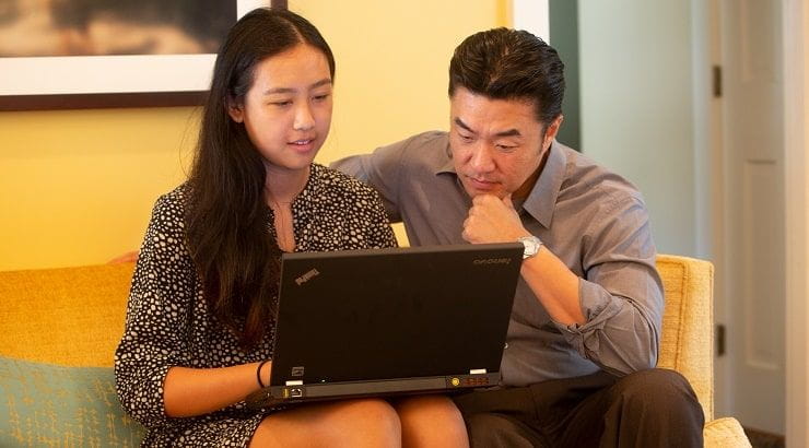 daughter and father looking at laptop