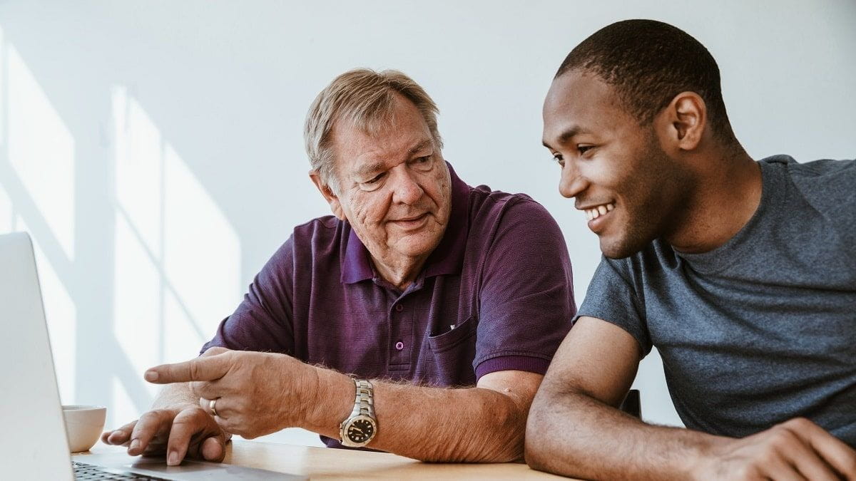 older man and young man working on computer