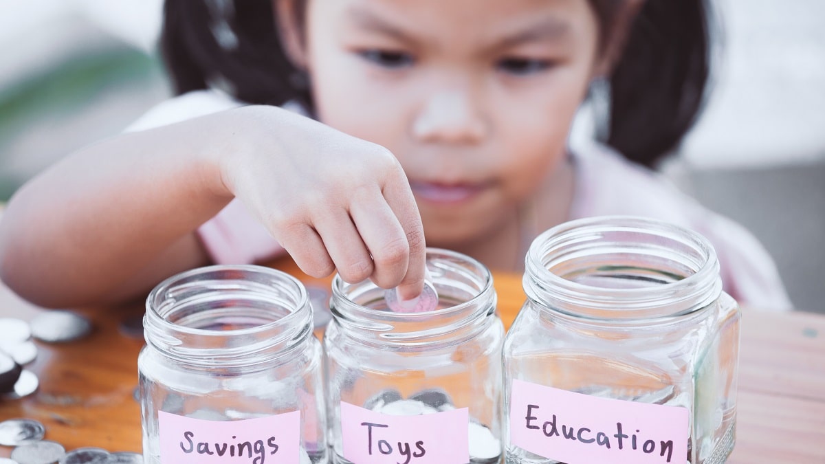 young girl saving money in jars