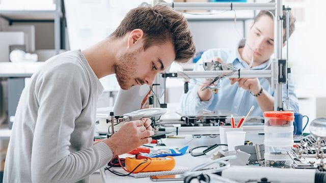 Teen focusing on work in engineering lab.